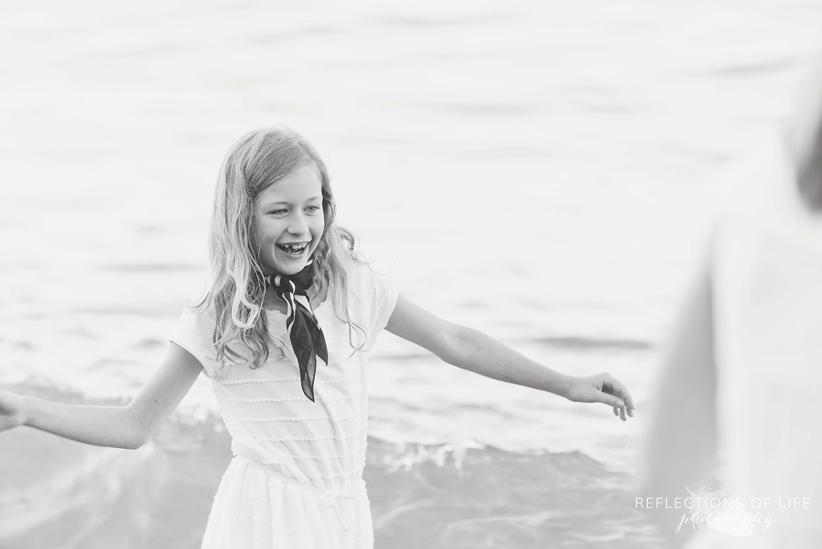 013 Little girl smiling on the beach in the waves