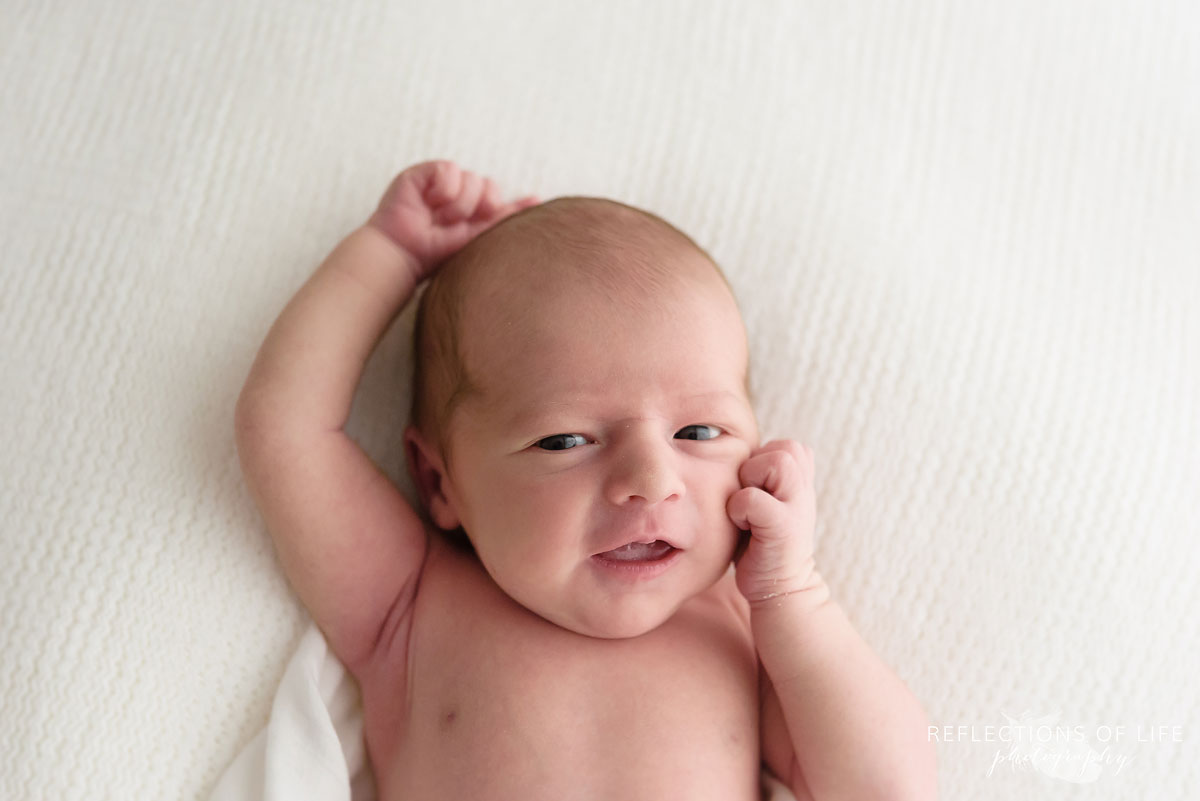 011 Niagara Newborn Photography baby thinking with hands by face