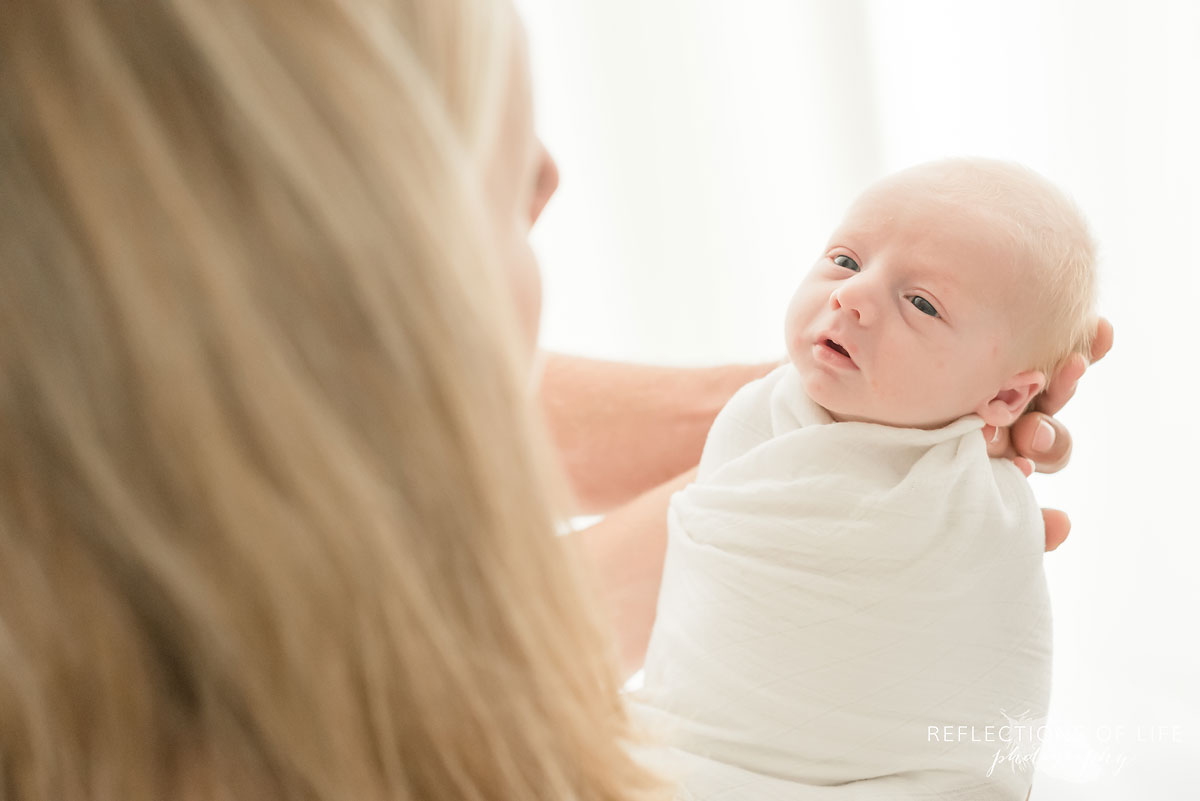 mom looking down at Newborn baby boy
