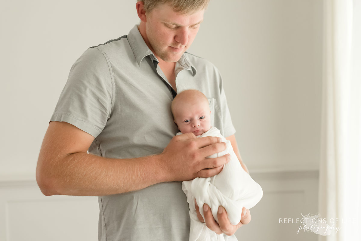 Portrait of dad holding baby boy by Toronto Baby Photographer