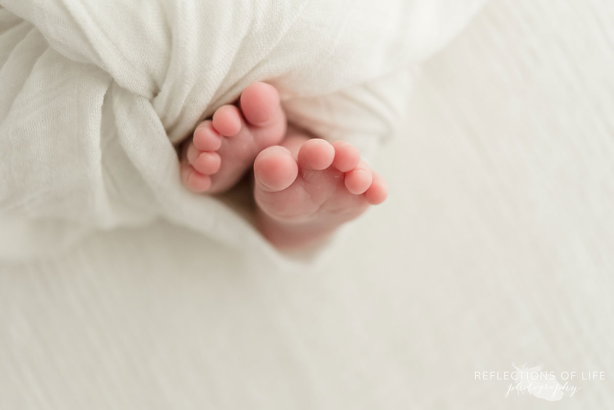 Adorable baby feet wrapped in white blanket