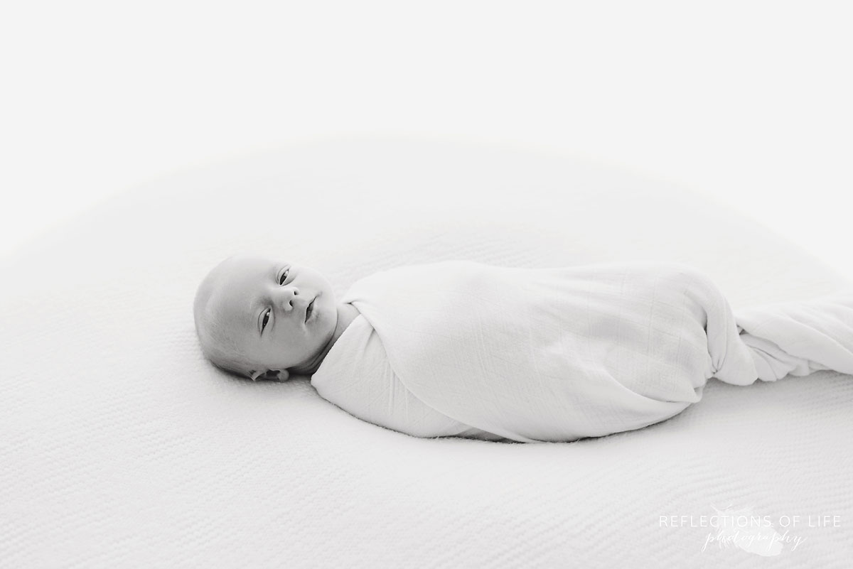 Black and white image of newborn baby on beanbag