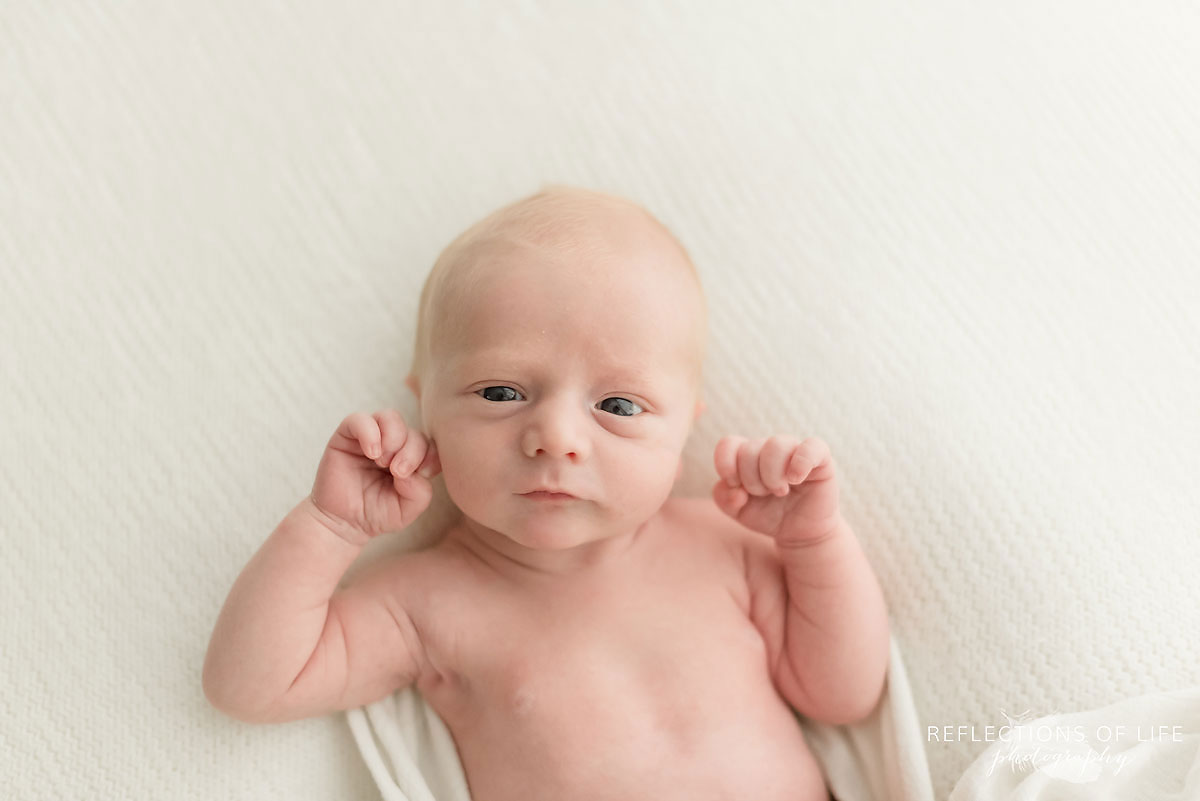 Colour-image-of-baby-wrapped-in-blanket-looking-at-the-camera.jpg