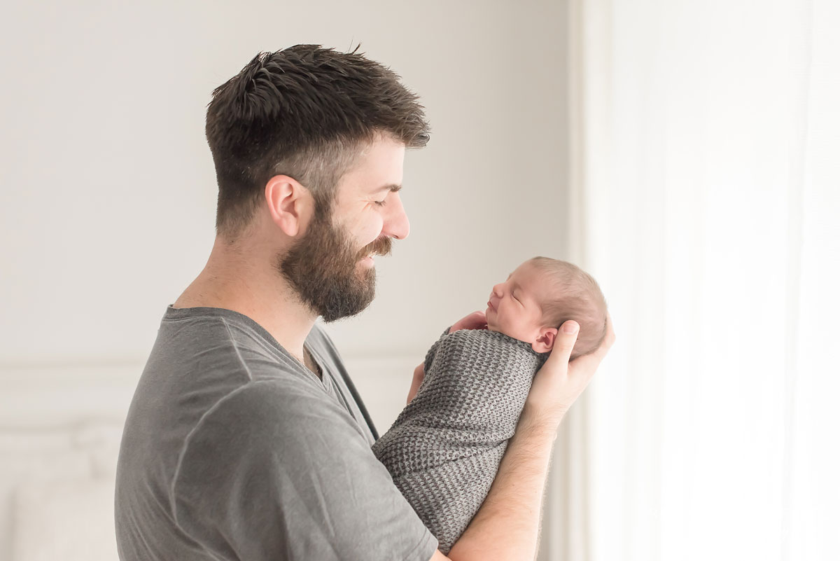 Newborn baby boy in arms of his daddy