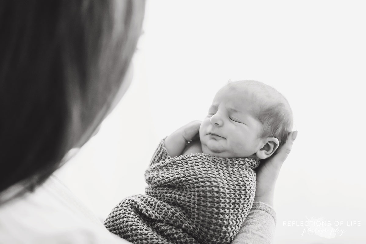 Mom looks down at newborn baby boy