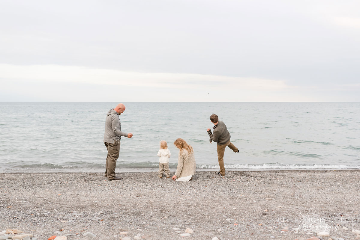 Family of four throwing rocks into the water at Grimsby Beach Ontario.jpg