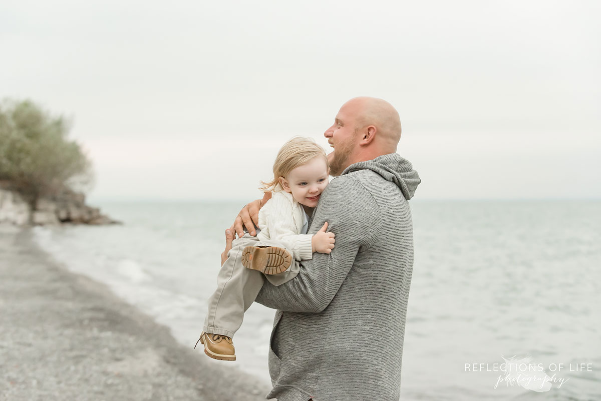 Father cuddling with his son on the beach in Niagara Region of Ontario Canada.jpg