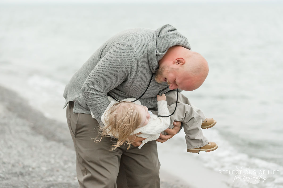 Father looking down at toddler son in Grimsby Ontario Canada on the beach.jpg