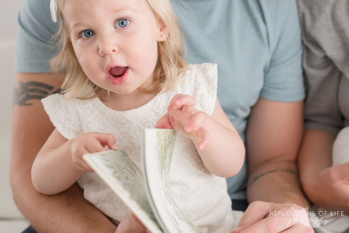 005 Little girl with surprised face reading a book in Niagara Ontario photo studio.jpg