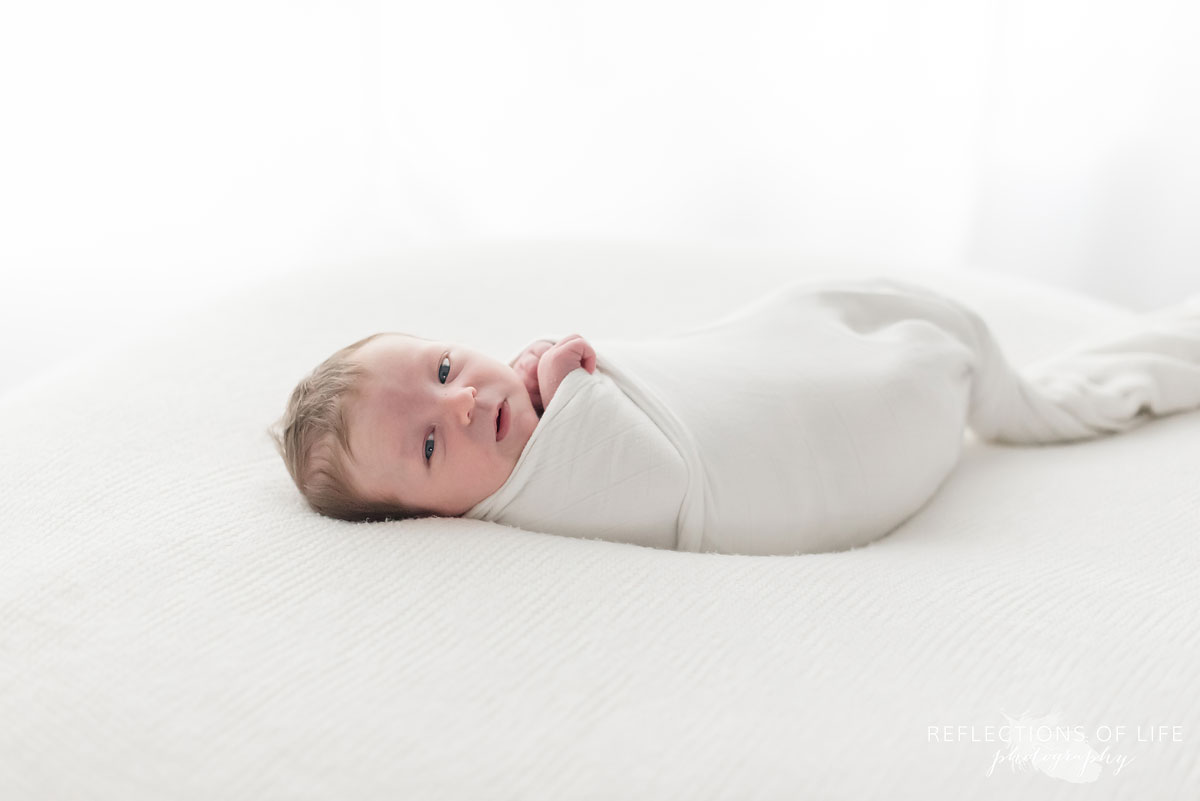 014 Colour image of newborn baby boy swaddled in white on white blanket.jpg