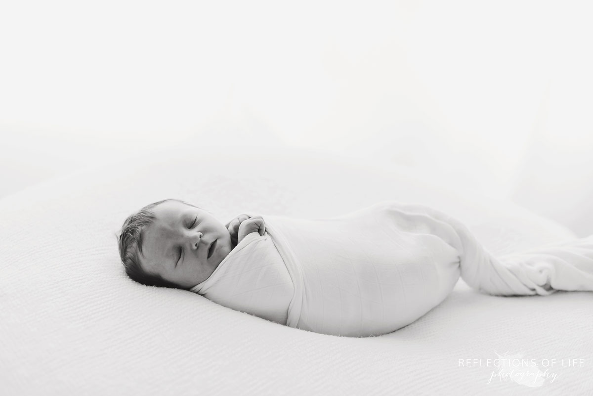 015 Black and white image of baby boy swaddled in white on white background.jpg