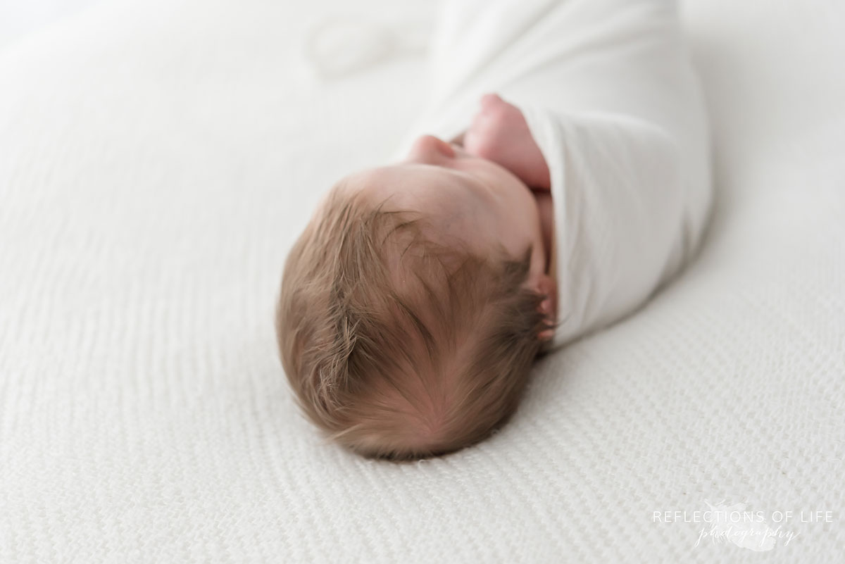 017 Professional photo of baby boy hair and swaddled in white.jpg