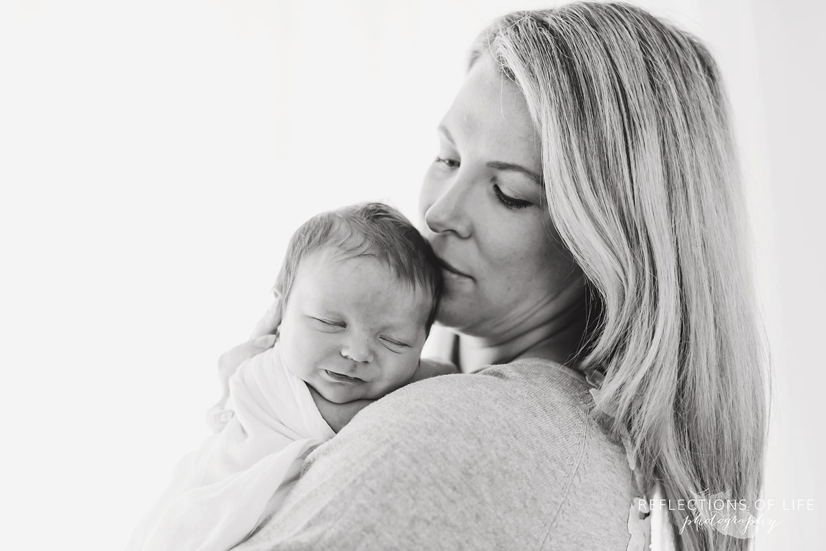 024 Black and white image of baby boy held on moms shoulder.jpg