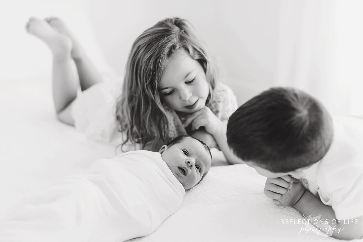 Niagara Newborn Photographer Ontario Canada Siblings looking down at newborn baby sister