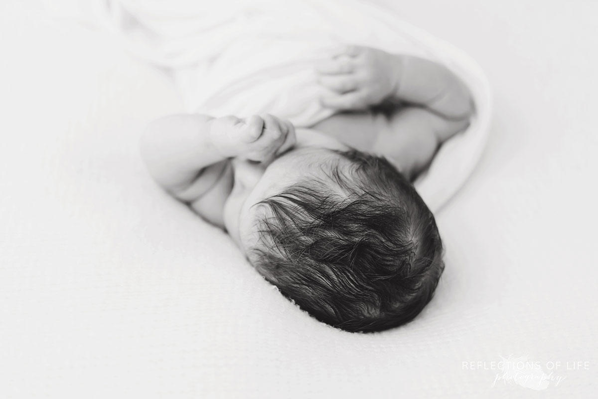 Natural light studio photo of baby hair in black and white