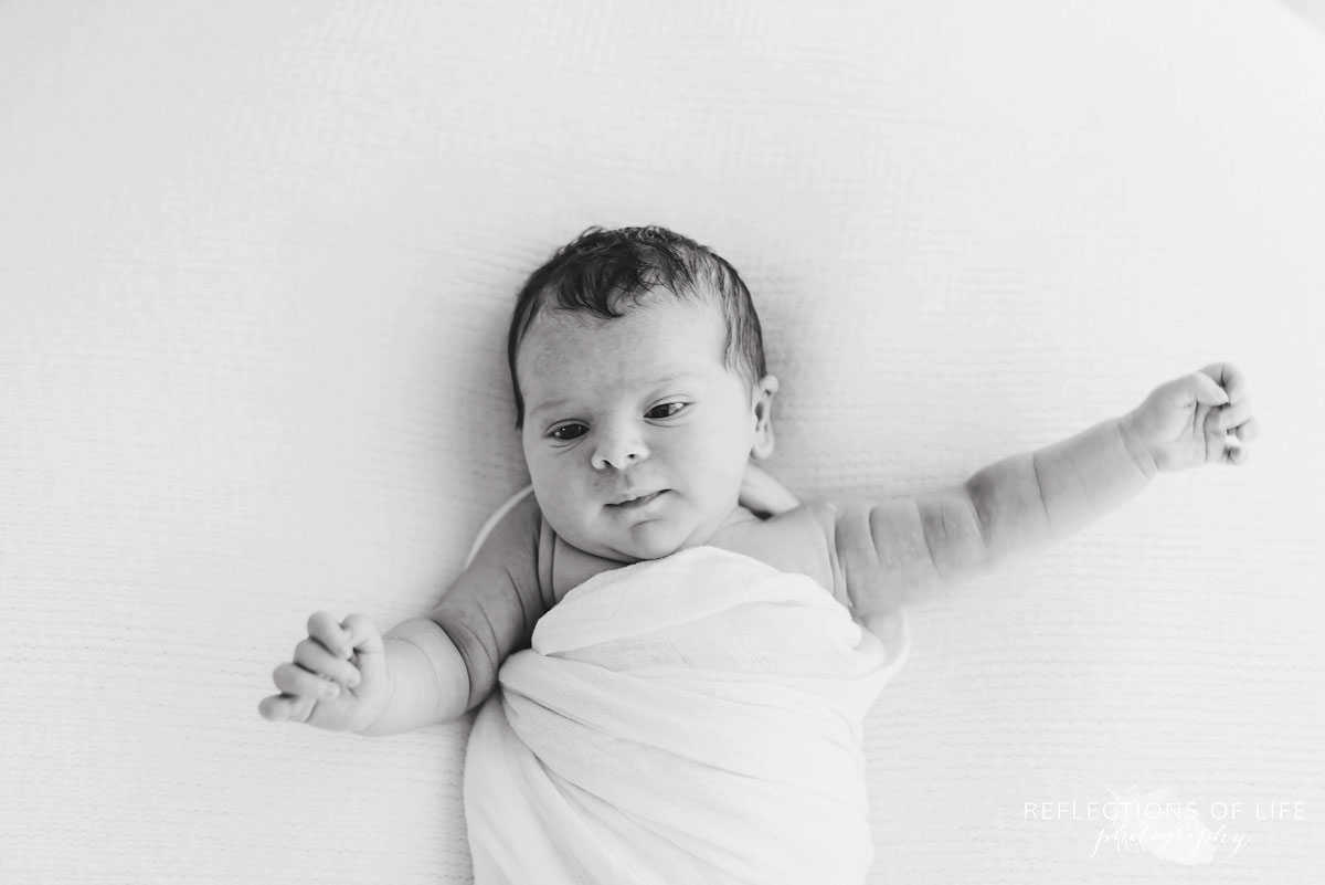 Little newborn girl baby stretching