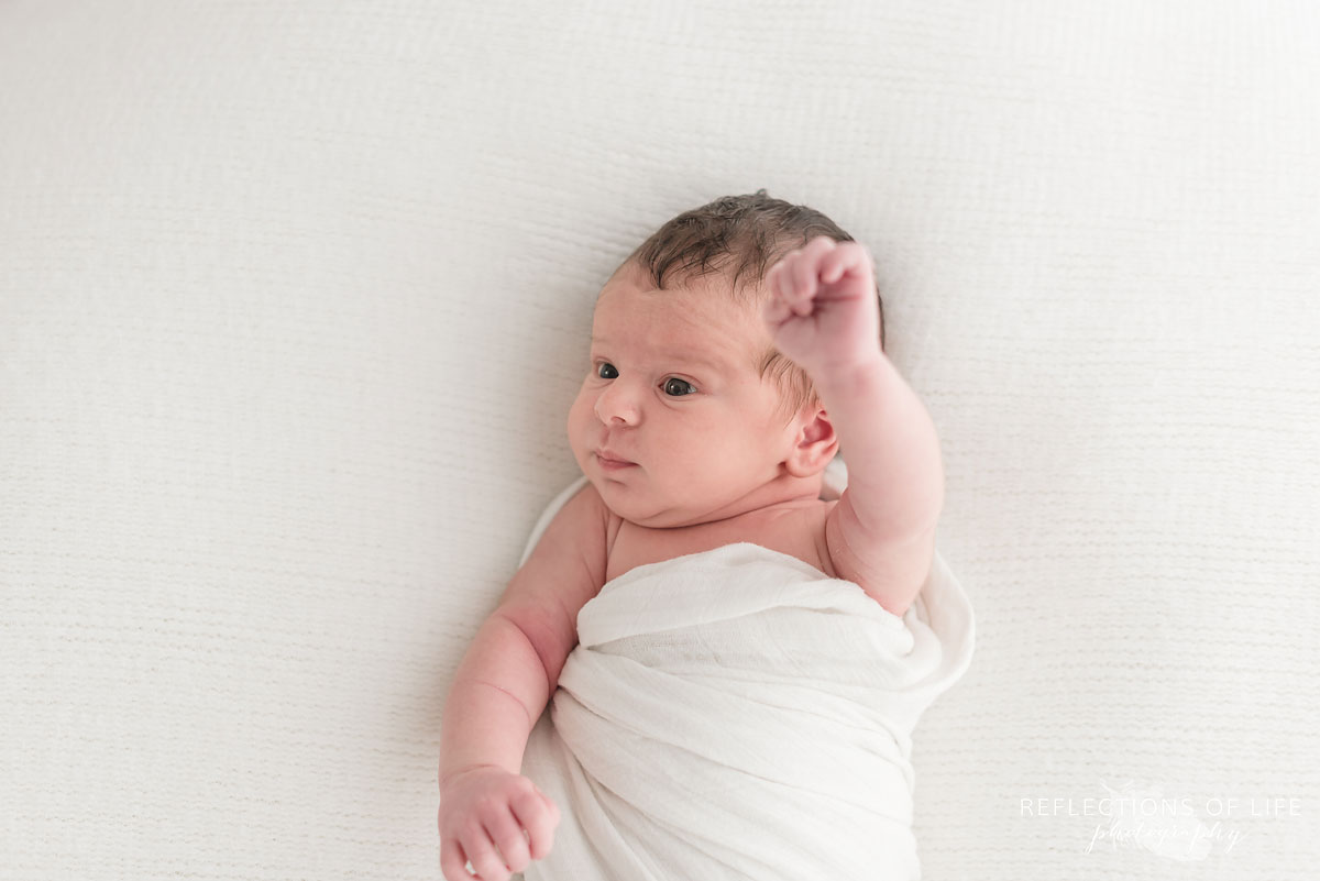 Little newborn baby girl stretching and moving