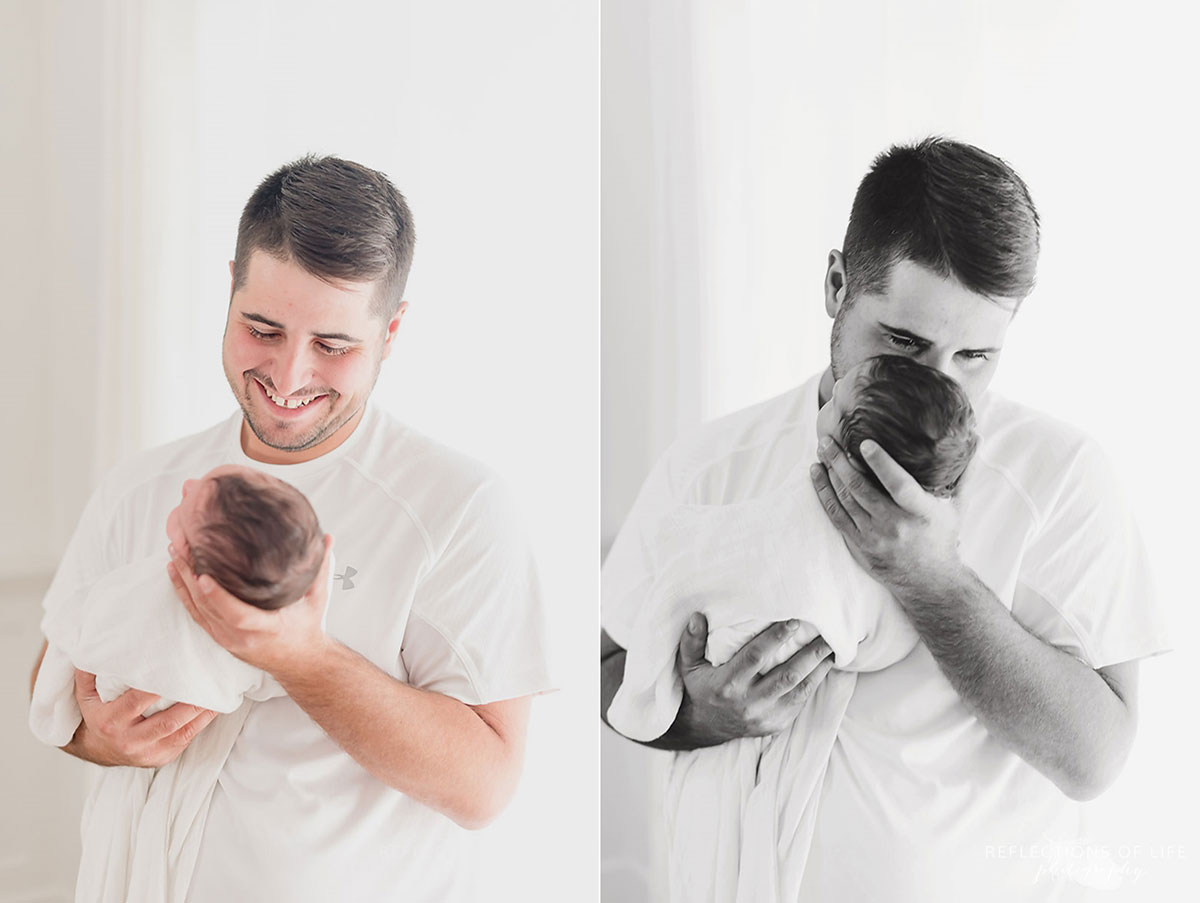 Daddy looking down at newborn baby girl with love and whispering to her