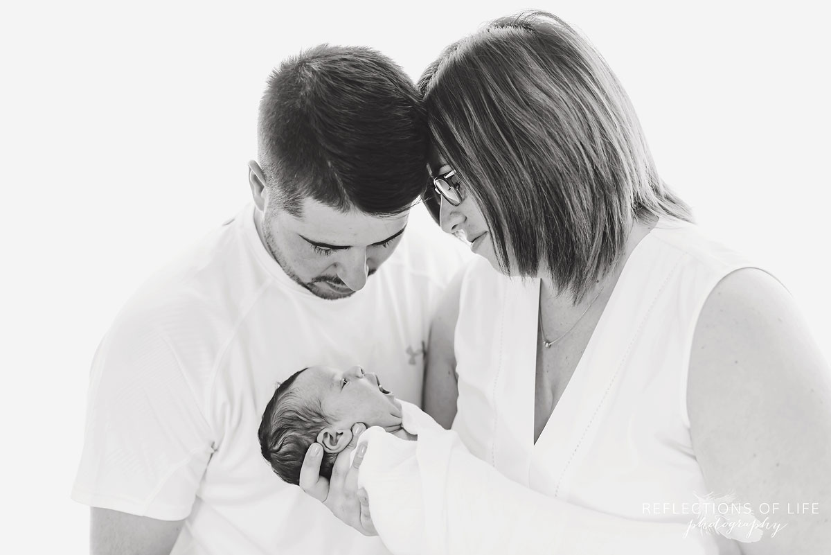 Mother and father looking down at newborn baby girl