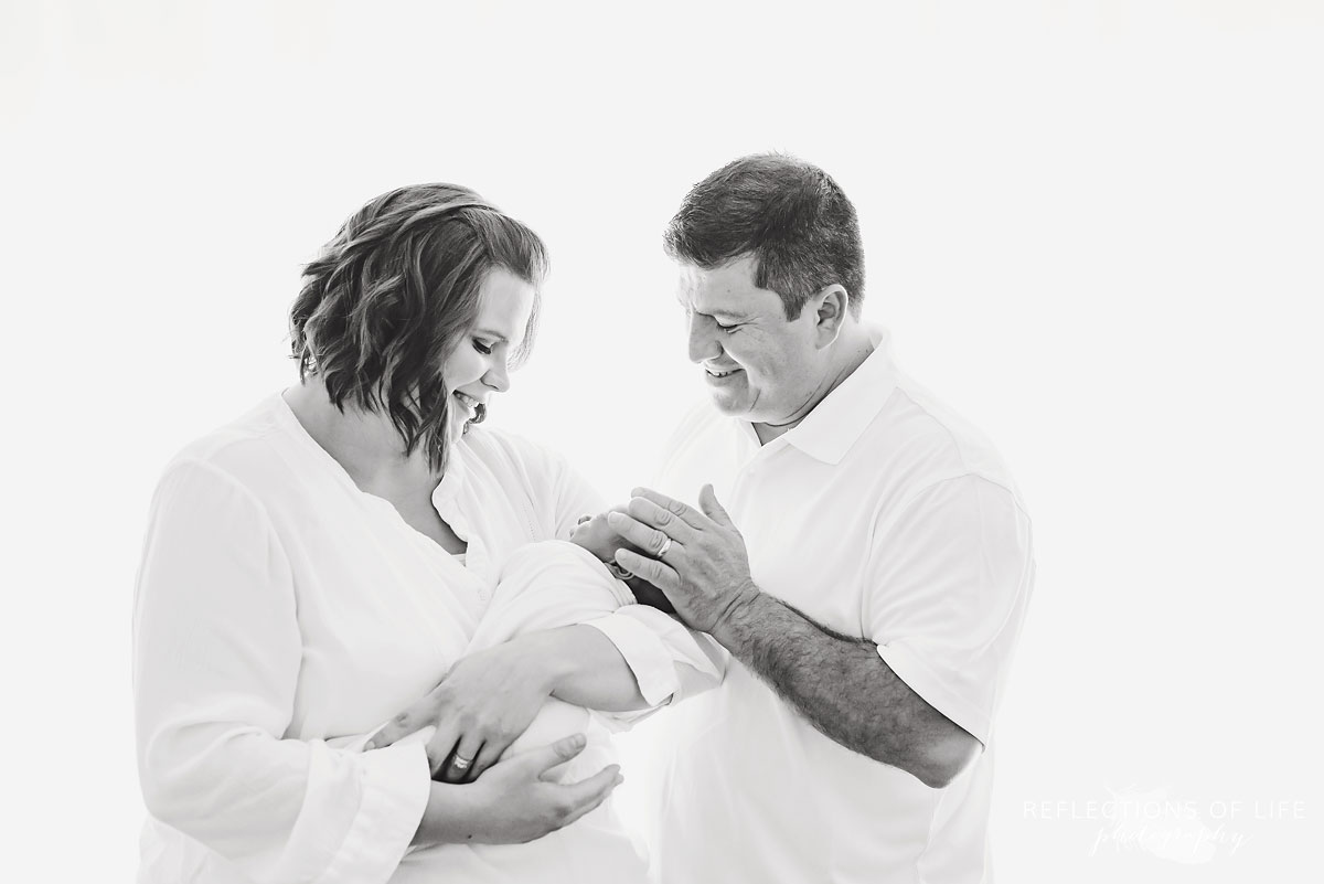 Natural light photo of mother and father holding their precious newborn baby boy Jaxon