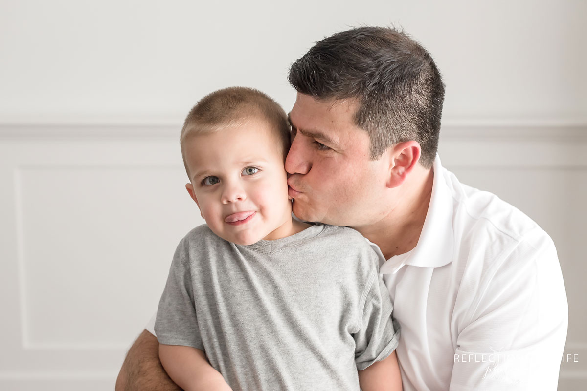 Dad giving his son a kiss on the cheek
