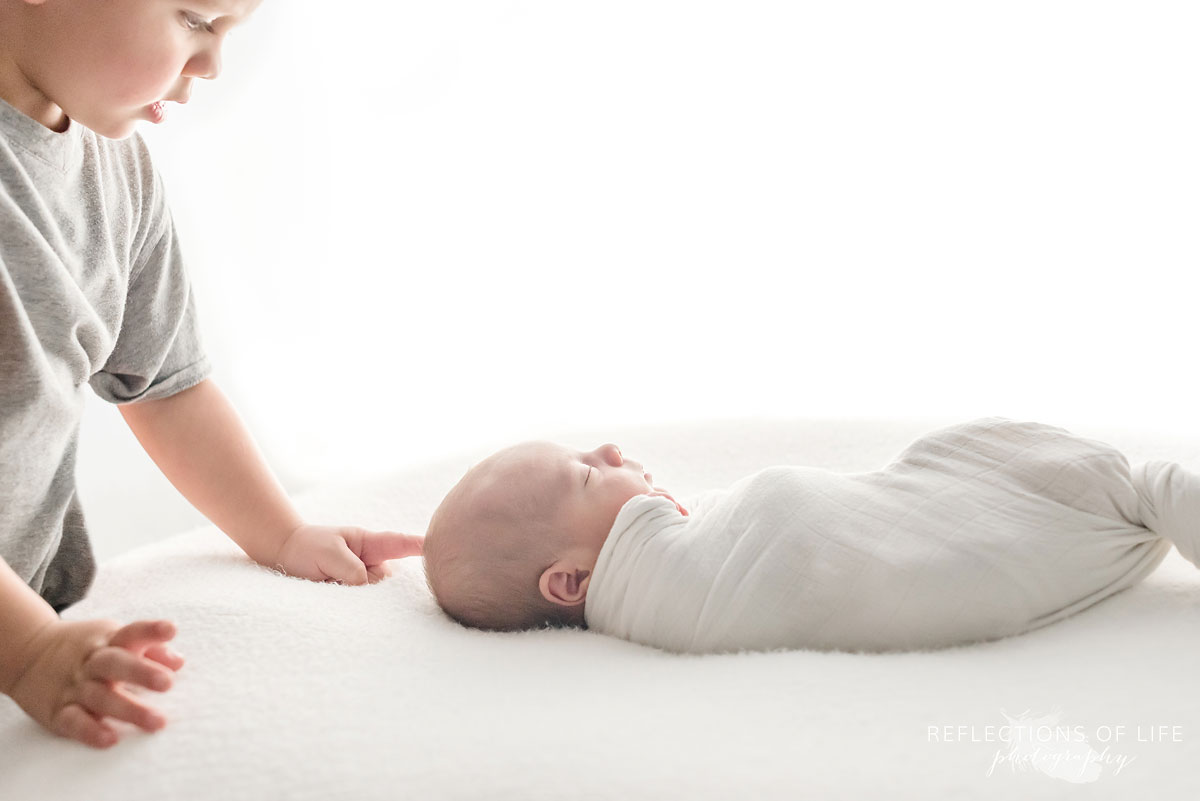 Sibling photo of big brother and newborn baby brother