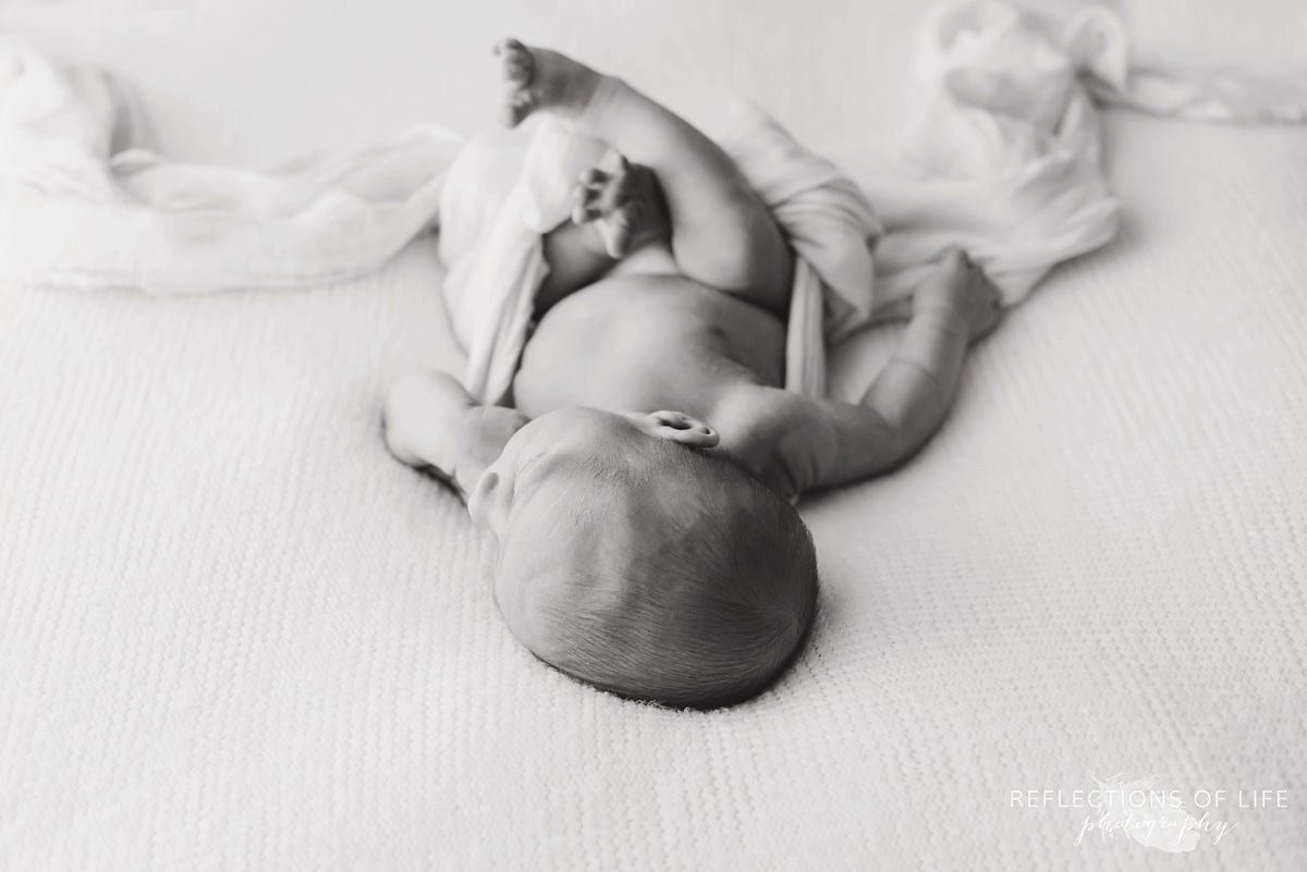 Artistic image of newborn baby boy in black and white