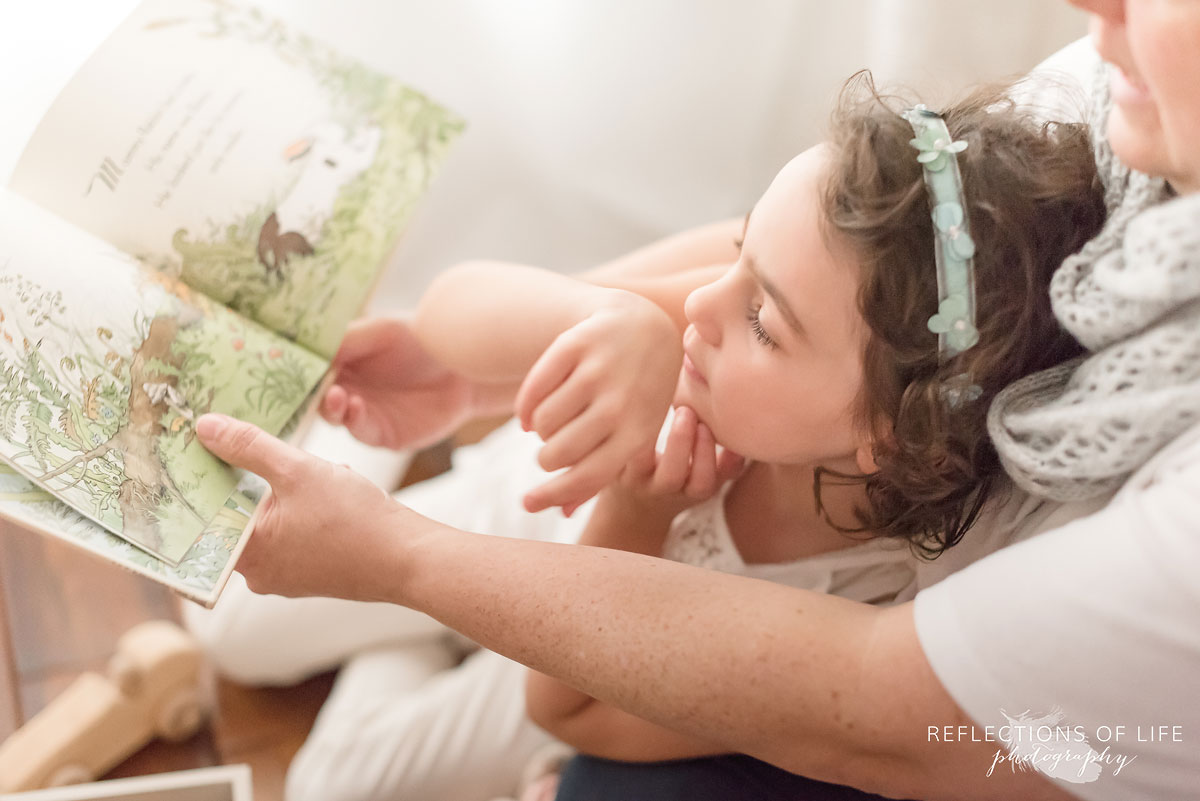 daughter reading in mothers lap