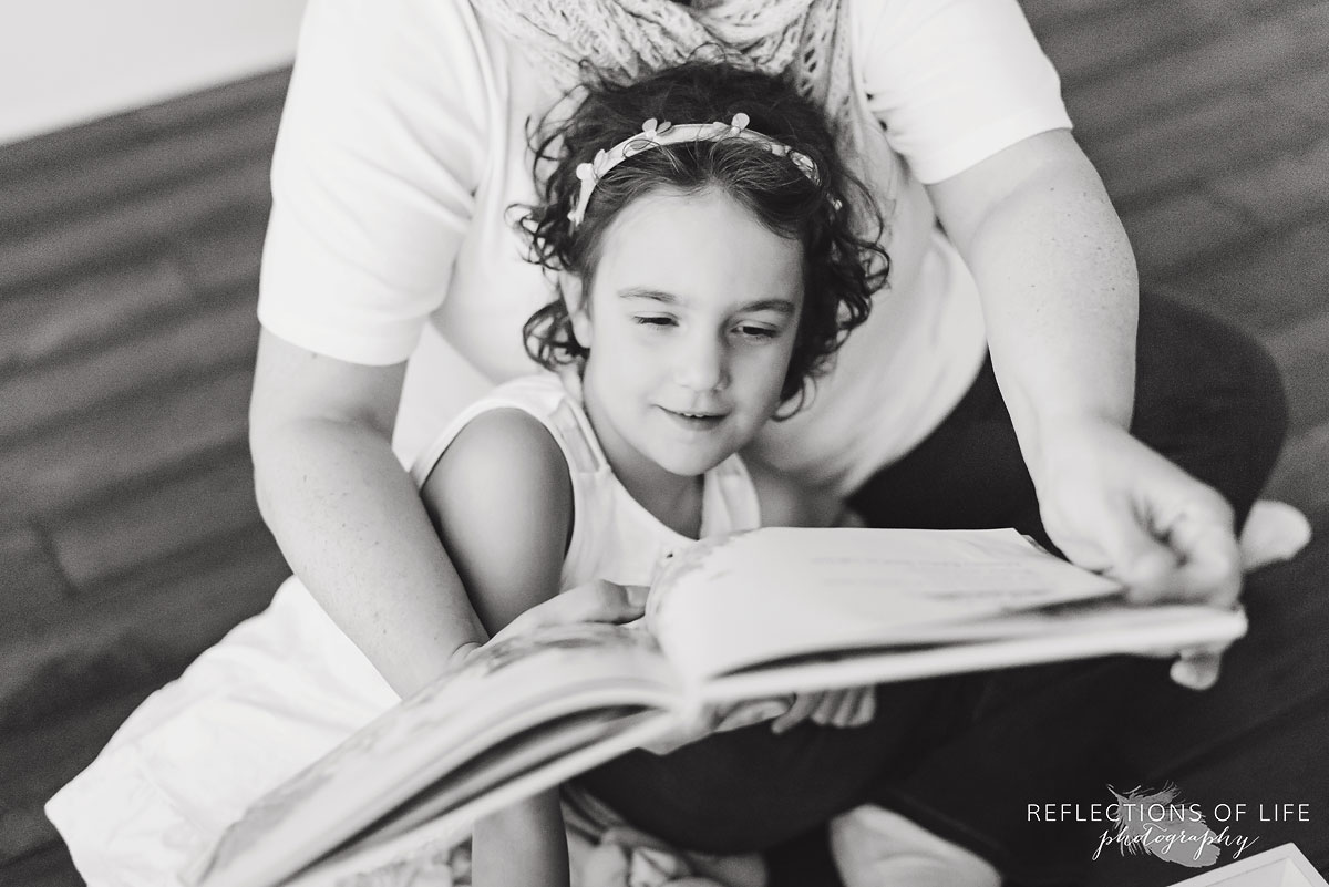mother reading to daughter black and white