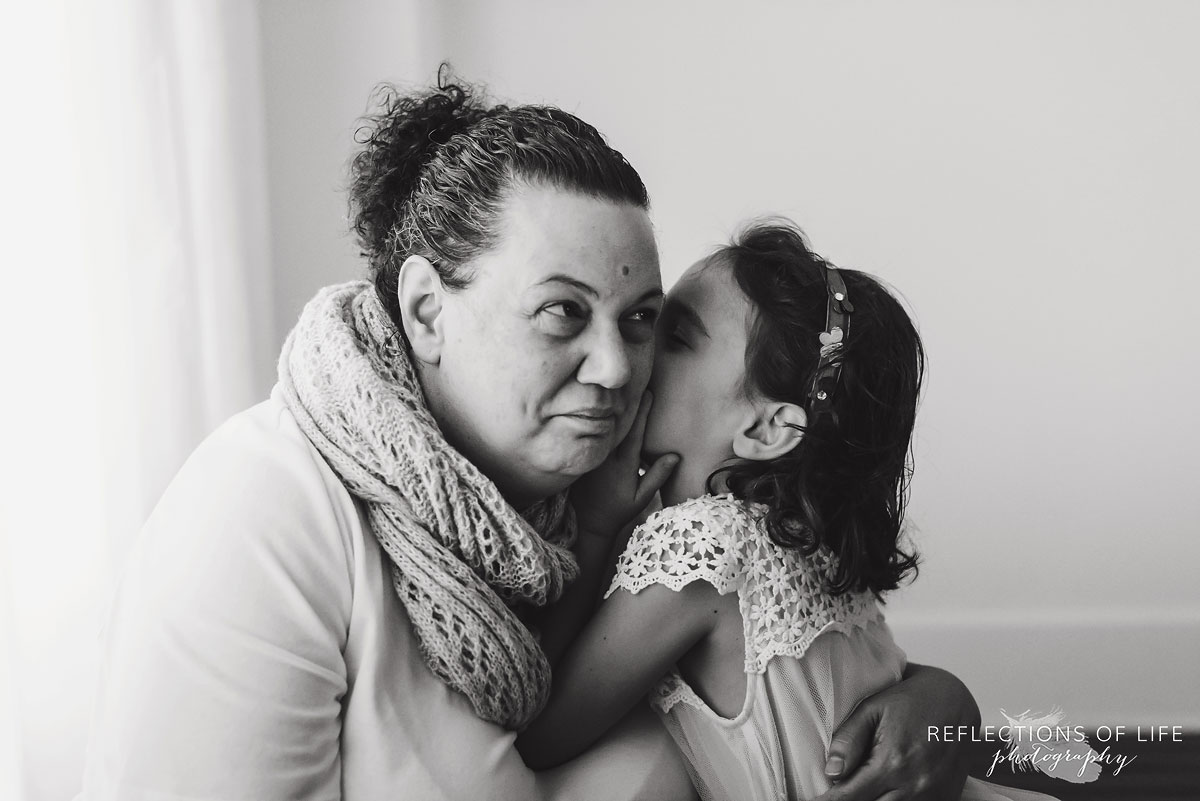 daughter giving mother a kiss black and white
