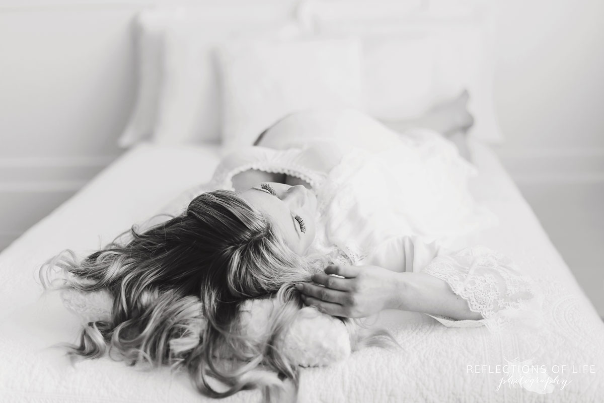black and white pregnant women laying on bed