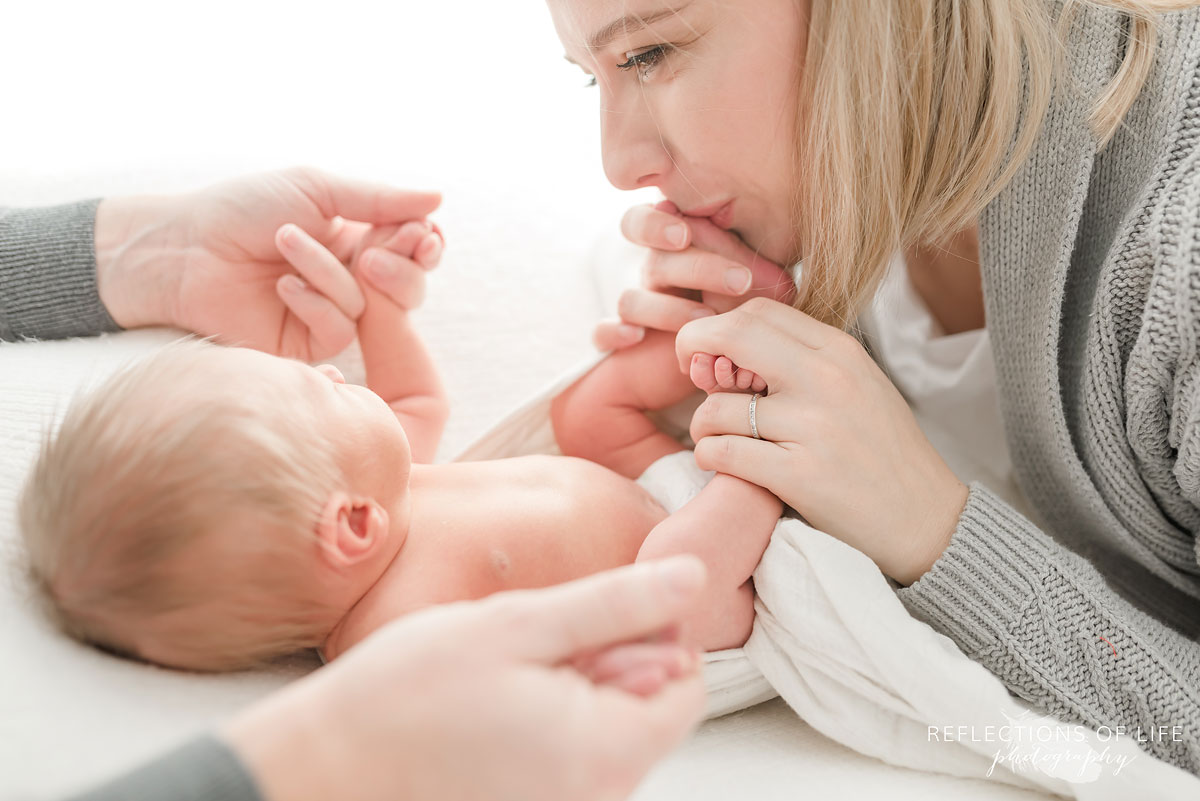 mother and father playing with newborn baby