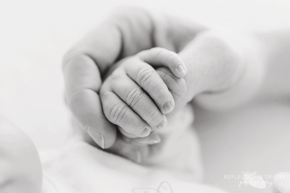 parent holding childs hand black and white