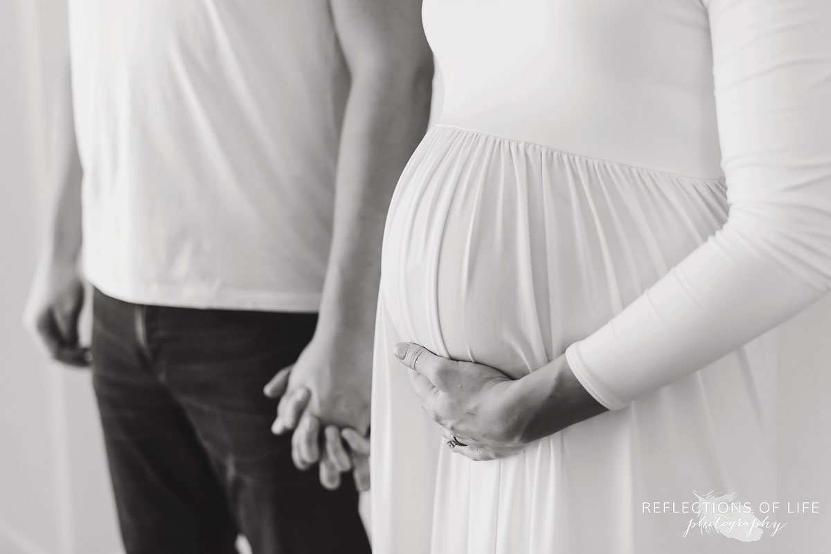 black and white mother and father holding hands pregnant