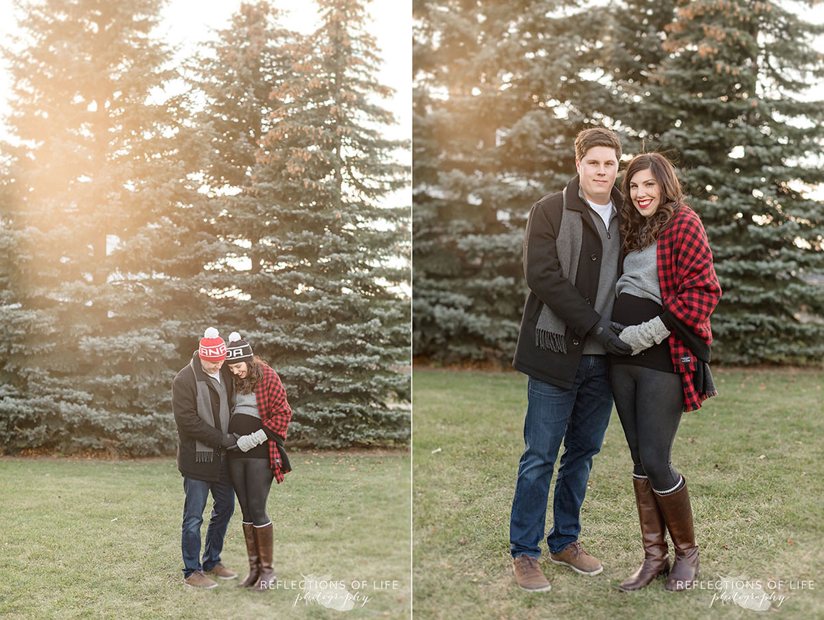 mother and father to be standing in front of christmas trees