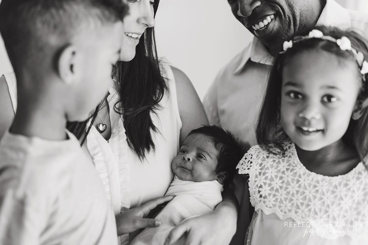 black and white happy family surounding baby