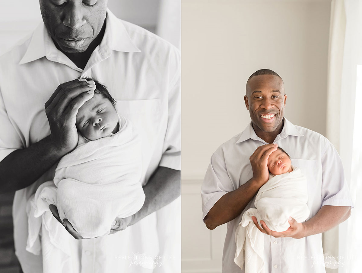 father holding newborn child in hands black and white and colour
