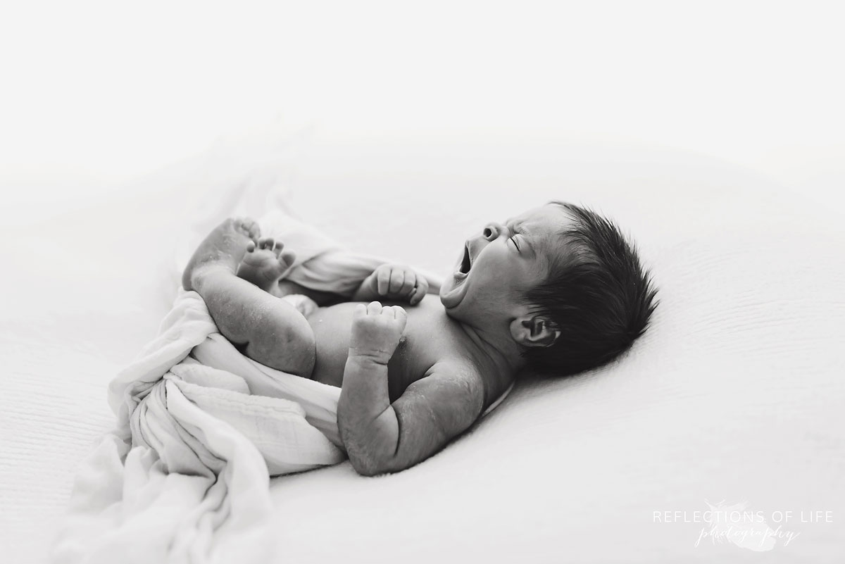 black and white newborn baby yawning