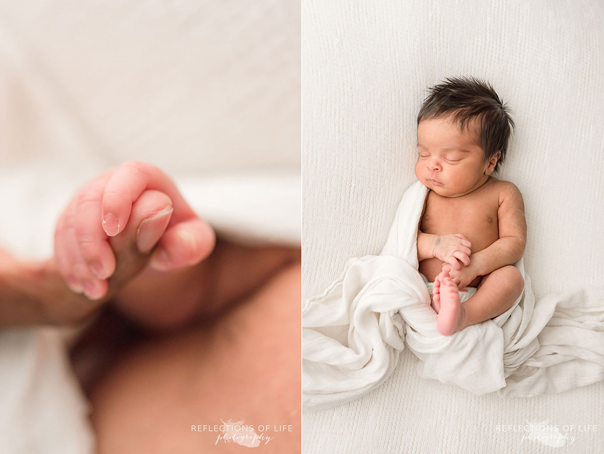 newborn laying on bed holding fathers finger