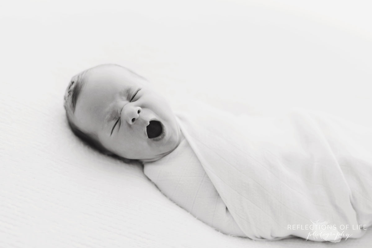 young baby boy yawning newborn black and white