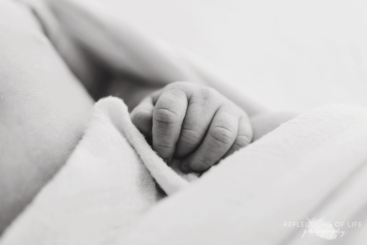 young baby boy newborn happy small hands detail black and white