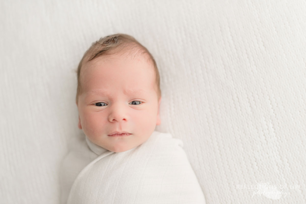 happy young baby boy looking straight into camera 