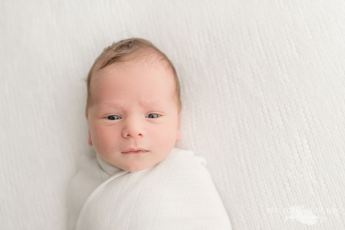 happy young baby boy looking straight into camera