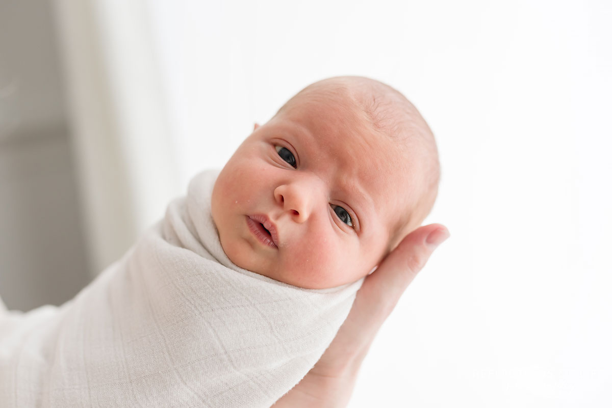 newborn baby girl looking into camera