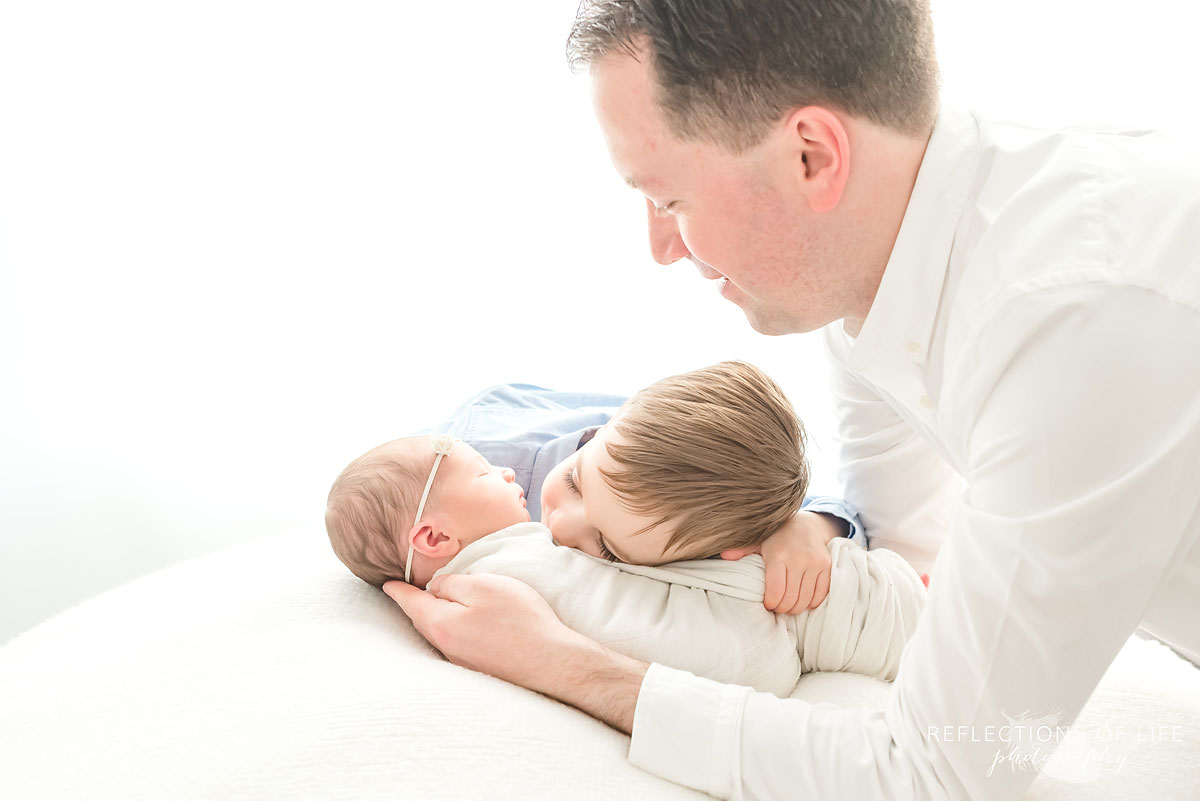 siblings hug on set of niagara newborn photographer studio grimsby ontario