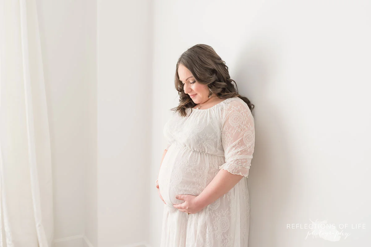 Gorgeous mom in white lace dress natural light studio maternity photo.jpg