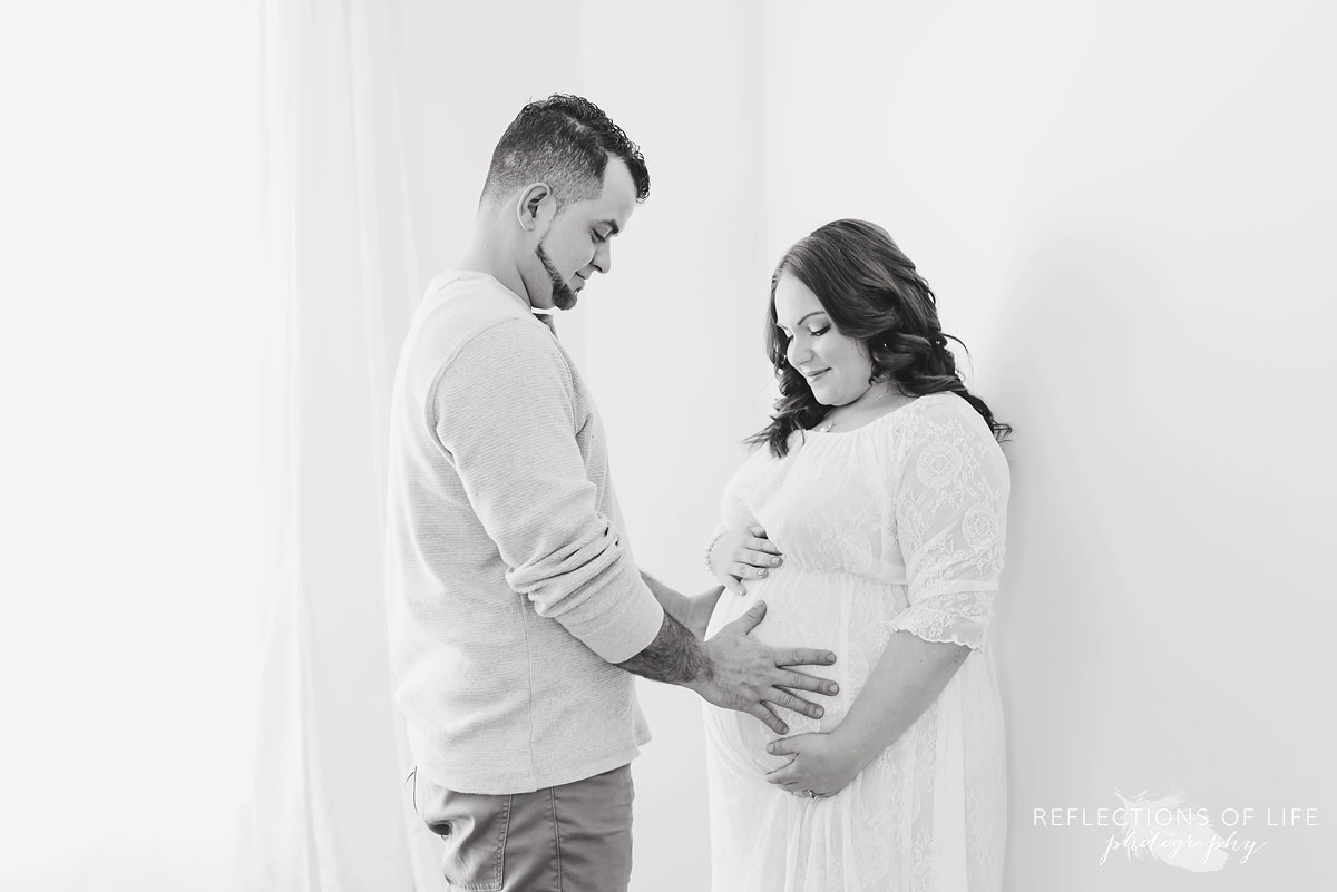 Maternity photography with mom and dad holding baby belly