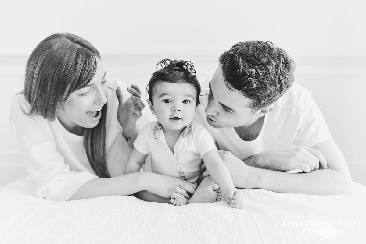 cute photo of baby with his parents in black and shite