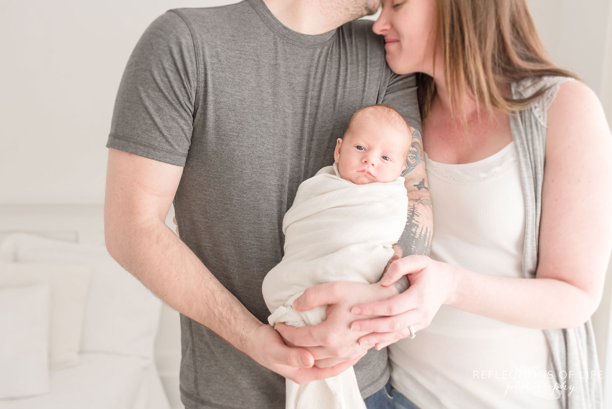 baby boy in arms of his proud mama and daddy
