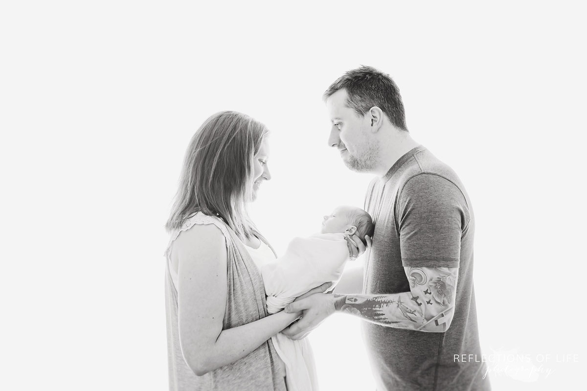 black and white portrait of parents holding newborn baby boy
